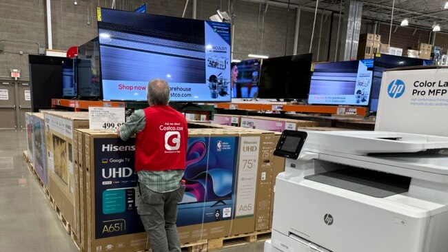 An associate checks over a big-screen television on display in a Costco warehouse Feb. 6, 2024, in Colorado Springs, Colorado. The U.S. Labor Department reported on Feb. 13 that the consumer price index rose 0.3% from December to January.