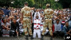 FILE - Ethiopian soldiers try to stop protesters in Bishoftu, in the Oromia region of Ethiopia.