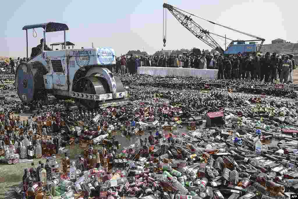 Seorang petugas menggunakan mesin gilas untuk menghancurkan botol-botol alkohol dan obat-obatan ilegal yang diselundupkan ke Pakistan dalam sebuah acara pemusnahan barang-barang ilegal di Karachi.