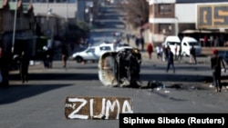 Voiture brûlée et rue bloquée à Johannesburg, en Afrique du Sud, le 11 juillet 2021, suite à de violentes manifestations après l'incarcération de l'ancien président Jacob Zuma.