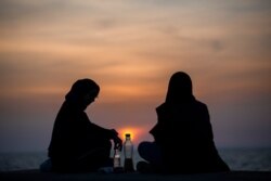 Muslim women break their fast during the Muslim holy fasting month of Ramadan along the seaside promenade in Beirut, Lebanon, April 15, 2021.