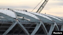 FILE - Inspectors check the work area on the roof of the Arena Amazonia stadium under instructions from the local prosecutor's office in Manaus, Brazil, Dec. 17, 2013. 