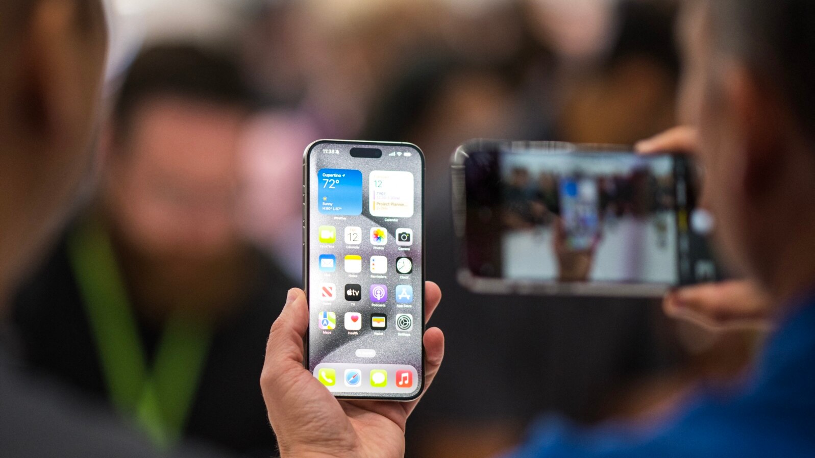 A person looks at an Apple iPhone 15 Pro during a launch event at Apple Park in Cupertino, California, on September 12, 2023. (Photo by Nic Coury / AFP)