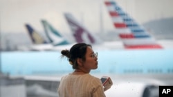 Seorang wanita di Bandara Internasional Hong Kong, Senin, 12 Agustus 2019. Ini adalah salah satu bandara tersibuk di dunia. (Foto: AP/Vincent Thian)