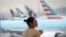 Une femme se tient debout avec son téléphone portable à l'aéroport international de Hong Kong, le lundi 12 août 2019. 