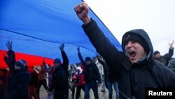 Manifestantes marchan bajo una bandera rusa en la ciudad de Simferopol, en Crimea.