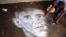 Percy Maimela, a self taught artist, puts finishing touches to a sand portrait of former U.S. President Barack Obama, at his home in Pretoria, South Africa.