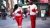 Una pareja con suéteres a juego con el tema del corazón camina de la mano por Times Square el día de San Valentín en la ciudad de Nueva York, el 14 de febrero de 2023. REUTERS/Mike Segar