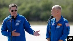 NASA astronauts Robert Behnken, left, and Doug Hurley speak during a news conference after they arrived at the Kennedy Space Center in Cape Canaveral, Fla., May 20, 2020. 