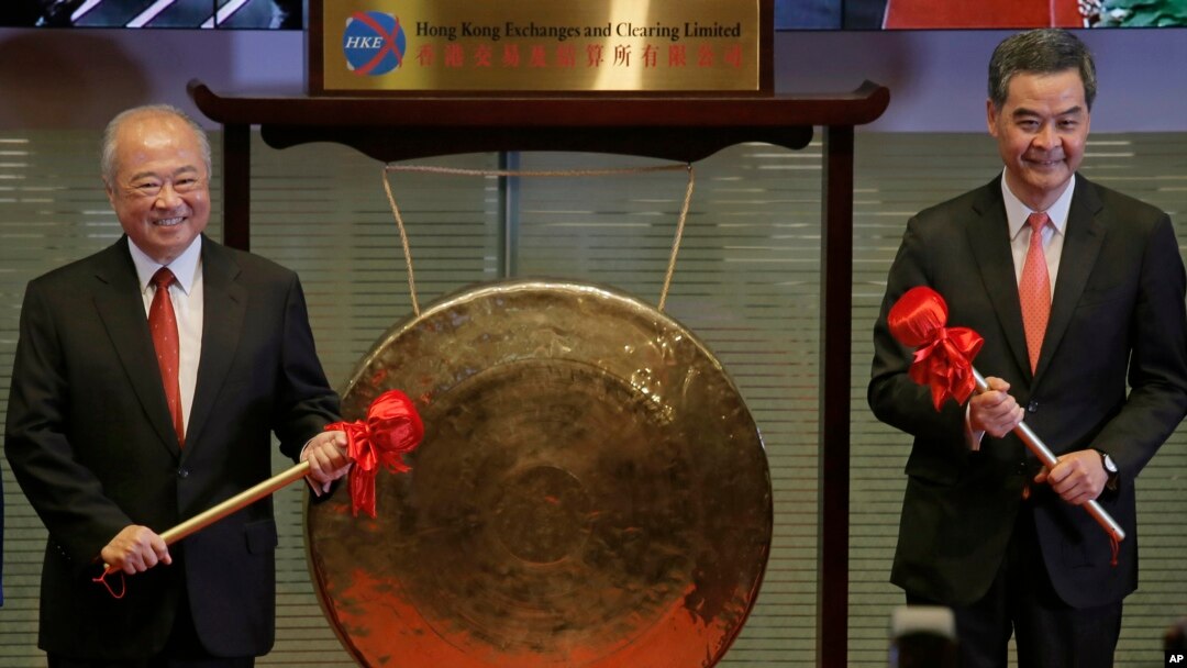 Hong Kong Exchanges and Clearing Ltd. Chairman Chow Chung-kong, left, and Hong Kong Chief Executive Leung Chun-ying pose before beating a gong during the launch ceremony of the Shanghai-Hong Kong Stock Connect in Hong Kong Monday, Nov. 17, 2014.