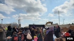 The gate to Manbij, Syria, where displaced families wait to enter, seeking relative safety hundreds of kilometers from Idlib. Feb. 21, 2020. (Heather Murdock/VOA)