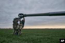 Tentara Ukraina menyiapkan howitzer M777 yang dipasok AS untuk ditembakkan ke pasukan Rusia di wilayah Kherson, Ukraina, 9 Januari 2023. (Foto: AP/Libkos)