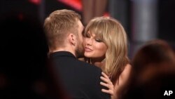 Taylor Swift (kanan) memeluk Calvin Harris setelah memenangkan penghargaan di ajang Billboard Music Awards, di Las Vegas bulan Mei lalu.