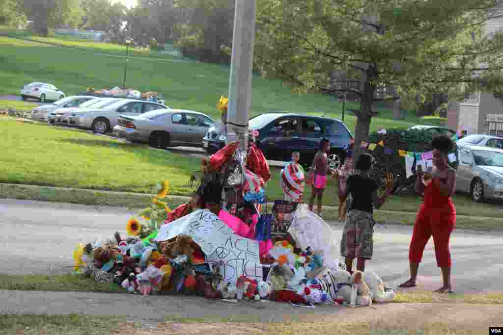 Cientos de personas se acercan al sitio en donde Michael Brown murió en manos de agente Darren Wilson, para rendir una especie de homenaje al joven afroestadounidense. [Foto: Gesell Tobias, VOA]