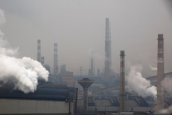 FILE - Smoke and steam rise from a steel plant in Anyang, Henan province, China, Feb. 18, 2019.