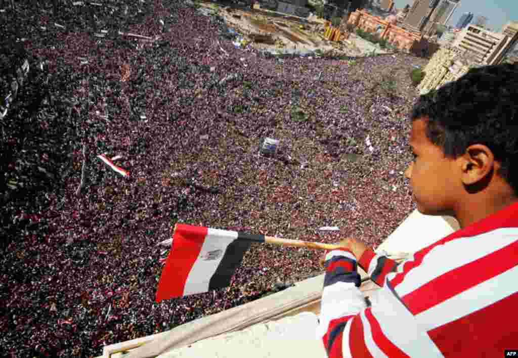 A boy watches as pro-democracy supporters gather in Tahrir Square in Cairo on Friday. Egyptians held a nationwide "Victory March" to celebrate the overthrow of Hosni Mubarak's 30-year rule one week ago (Reuters/Mohamed Abd El-Ghany)