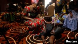 Dua orang perempuan menghibur seorang ibu dari siswi yang termasuk dalam 200 korban penculikan di Chibok, usai jumpa pers di Lagos, Nigeria (5/6). (Reuters/Akintunde Akinleye)