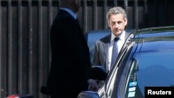 Cựu Tổng thống Pháp Nicolas Sarkozy (phải) rời khỏi tư gia ở Paris, ngày 2/7/2014.