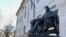 La estatua de John Harvard, en la prestigiosa universidad que lleva su nombre, fue decorada con una mascarilla en los días más críticos de la pandemia. Ahora la universidad se prepara para recibir a una parte de sus estudiantes.