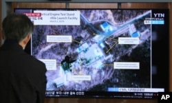 FILE - A man watches a TV broadcast showing an image of the Sohae Satellite Launching Station in Tongchang-ri, North Korea, during a news program shown at the Seoul Railway Station in Seoul, South Korea, March 6, 2019.