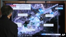 FILE - A man watches a TV screen showing an image of the Sohae Satellite Launching Station in Tongchang-ri, North Korea, during a news program at a Seoul rail station, March 6, 2019. North Korea said Dec. 8 that it carried out a key test at the site.