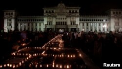 Outside National Palace in Guatemala City, people light candles during a vigil for victims of a fire at the Virgen de Asuncion home in San Jose Pinula, March 9, 2017.