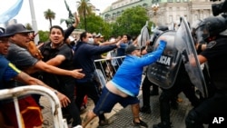 Soccer fans waiting to see Diego Maradona lying in state clash with police outside the presidential palace in Buenos Aires, Argentina, Thursday, Nov. 26, 2020. The Argentine soccer great who led his country to the 1986 World Cup died Wednesday at…