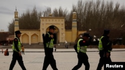 Polisi berpatroli di depan Masjid Id Kah di kota tua Kashgar, Daerah Otonomi Xinjiang Uighur, China, 22 Maret 2017. (Foto: dok).