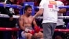 FILE - Trainer Freddie Roach speaks to Manny Pacquiao between rounds against Yordenis Ugas, of Cuba, in a welterweight championship boxing match in Las Vegas, Aug. 21, 2021. Pacquiao is officially hanging up his gloves. FILE - Trainer Freddie Roach speaks