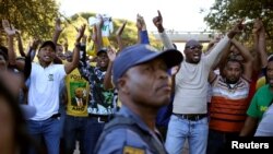 Un policier devant des manifestants à Mahikeng, en Afrique du Sud, le 20 avril 2018.