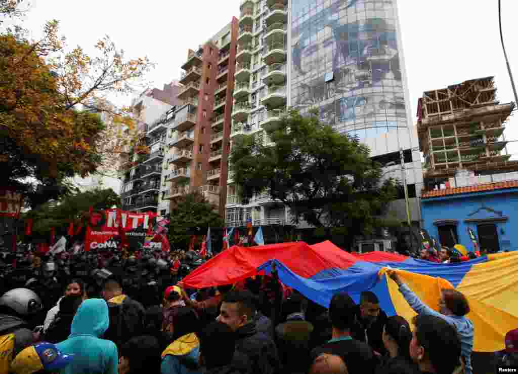 Manifestantes sostienen una bandera de Venezuela durante una protesta en apoyo al presidente interino de Venezuela, Juan Guaidó, frente a la embajada venezolana en Buenos Aires, Argentina, el 30 de abril de 2019.&nbsp;