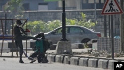 Police officers detain a protester at the Lekki toll gate in Lagos, Nigeria. After 13 days of protests against alleged police brutality, authorities have imposed a 24-hour curfew in Lagos.