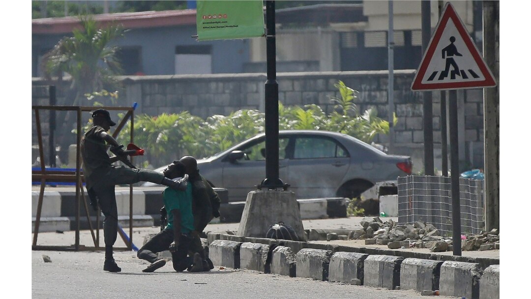 Police officers detain a protester at the Lekki toll gate in Lagos, Nigeria, Oct. 21, 2020.