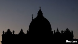 FILE - Saint Peter's Basilica is silhouetted against the sky at the Vatican, Dec. 16, 2023.