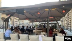 Bars and restaurants have gone back to being populated in Florence and many are enjoying their capuccinos sitting in the sun at the tables outside. (Sabina Castelfranco/VOA)