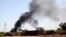 Smoke rises from the Brigade Qaqaa headquarters, a former Libyan Army camp known as Camp 7 April, following clashes between rival militias at the Sawani road district, Aug. 24,2014.