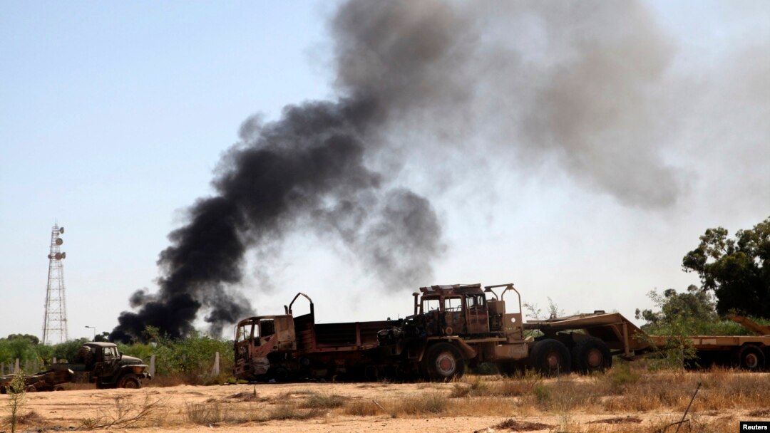 Smoke rises from the Brigade Qaqaa headquarters, a former Libyan Army camp known as Camp 7 April, following clashes between rival militias at the Sawani road district, Aug. 24,2014.