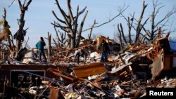 Residents sort through the rubble after their home was destroyed during a tornado in Washington, Illinois, Nov. 19, 2013. 