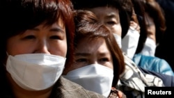 People wearing face masks stand in line to buy masks at a post office amid the rise in confirmed cases of coronavirus disease (COVID-19) in Daegu, South Korea, March 5, 2020. (REUTERS/Kim Kyung-Hoon)