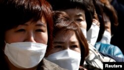 People wearing face masks stand in line to buy masks at a post office amid the rise in confirmed cases of coronavirus disease (COVID-19) in Daegu, South Korea, March 5, 2020. 