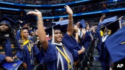 A graduate waves as students arrive Howard University's commencement in Washington, Saturday, May 13, 2023. (AP Photo/Alex Brandon)