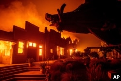 FILE - Flames from the Kincade Fire consume Soda Rock Winery in Healdsburg, Calif., Oct. 27, 2019.