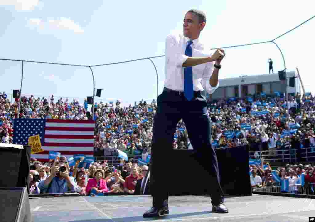 President Barack Obama swings with an imaginary bat as he arrives on stage to speak at a campaign event at G. Richard Pfitzner Stadium in Woodbridge, Virginia, Sept. 21, 2012. 
