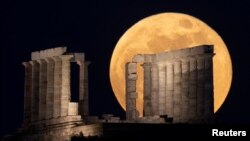 The full moon, known as the "Super Flower Moon" rises over the Temple of Poseidon in Cape Sounion, near Athens, Greece, May 26, 2021. 