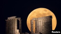 The full moon, known as the &quot;Super Flower Moon&quot; rises over the Temple of Poseidon in Cape Sounion, near Athens, Greece, May 26, 2021.
