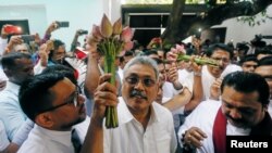 Gotabhaya Rajapaksa (C), former defense secretary and brother of Sri Lanka's ex-president Mahinda Rajapaksa, holds the symbol of the Sri Lanka People's Front, at a party event in Colombo, Sri Lanka, July 4, 2018.