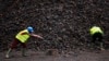 FILE - Workers are seen at a manganese mine in Lauzoua, some 180 km (112 miles) from Abidjan, Ivory Coast, Dec. 4, 2013. Botswana has granted a 15-year license to a Canadian firm to mine the metal, used for electric vehicle batteries. 