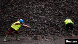 FILE - Workers are seen at a manganese mine in Lauzoua, some 180 km (112 miles) from Abidjan, Ivory Coast, Dec. 4, 2013. Botswana has granted a 15-year license to a Canadian firm to mine the metal, used for electric vehicle batteries. 