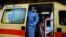 A paramedic wearing a suit to protect against coronavirus, closes the door of an ambulance at Evangelismos hospital in Athens, Nov. 12, 2020.