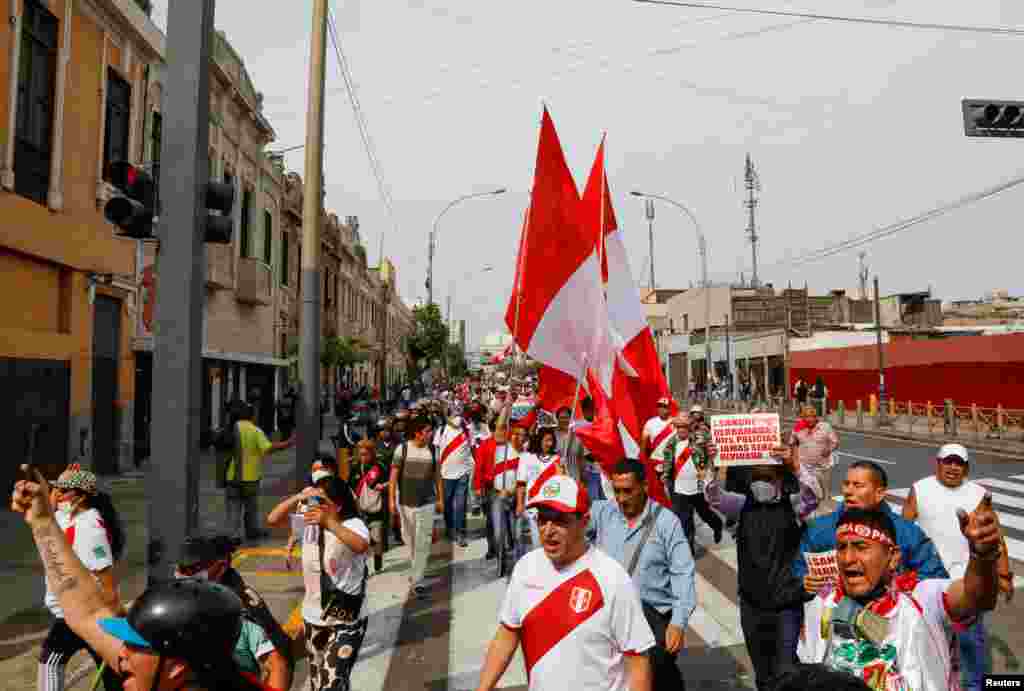 La gente grita y ondea banderas mientras asiste a una protesta después de que el Congreso aprobara la destitución del presidente Pedro Castillo, en Lima, Perú, el 7 de diciembre de 2022. REUTERS/Alessandro Cinque Lea más aquí sobre las convulsas presidencias en Perú